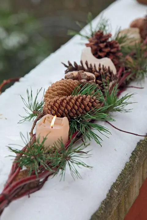 Наружное украшение свечами и сосновыми шишками