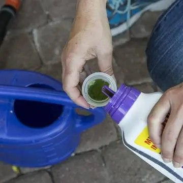 Поместите удобрение в лейку