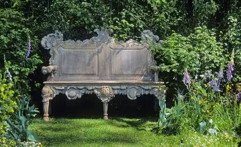 Украшенная каменная скамейка в саду