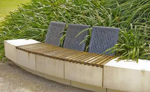 Полированная каменная скамья с деревянной подушкой и спинками