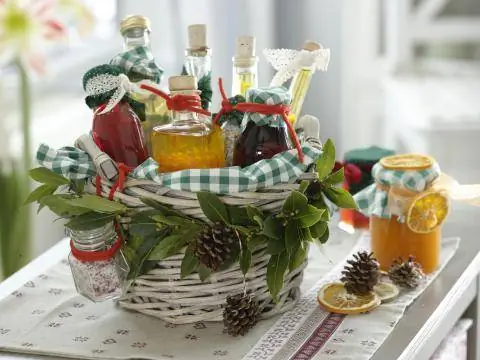 Украшенная корзина, полная бутылочек уксуса и масла.