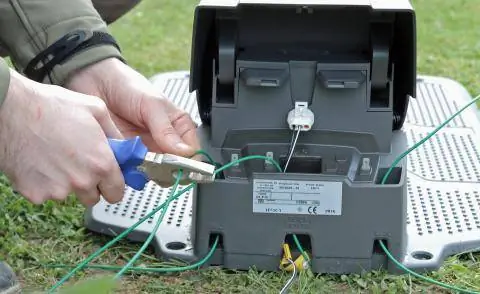 Подсоедините кабель к зарядной станции газонокосилки-робота.