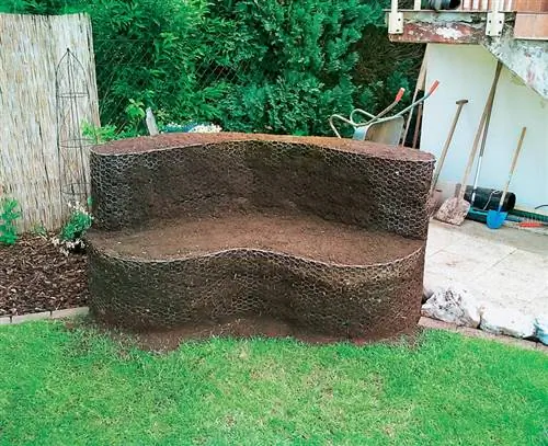 Нанесите смесь семян газона и почвы