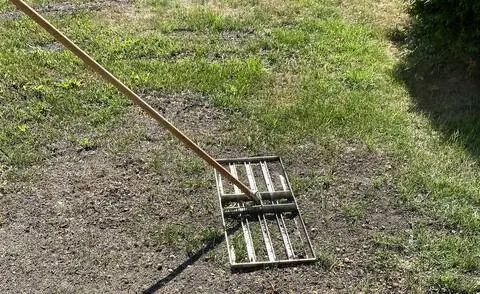 Выровняйте газон газонным скребком