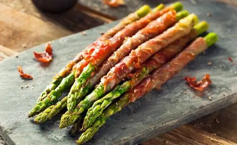 Зеленая спаржа на гриле с ветчиной
