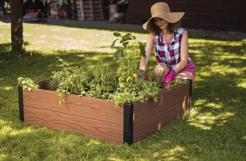 Женщина сажает растения на границе ложа Кетер