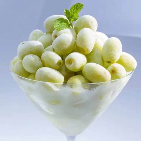 Замороженная гроздь винограда в бокале для мартини