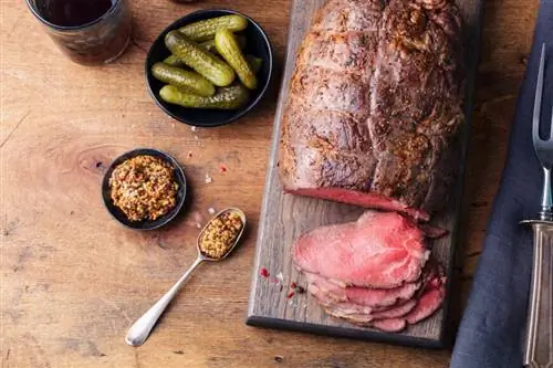 ростбиф на доске, горчица и соленые огурцы
