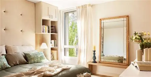 Спальня с большим стеганым изголовьем, зеркалом и книжным шкафом с гардеробной