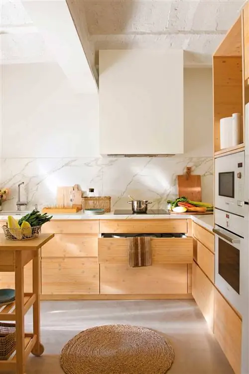 Кухня с микроцементным полом и деревянной мебелью.