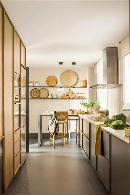 Узкая кухня со шкафами с двух сторон и барной стойкой на заднем плане.