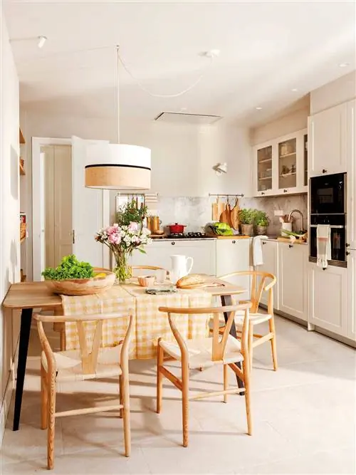 Цвет кухонного типа с кабинетом с деревянным столом.