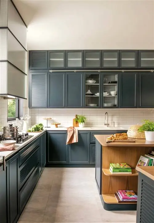 Кухня с деревянной и темно-зеленой мебелью.