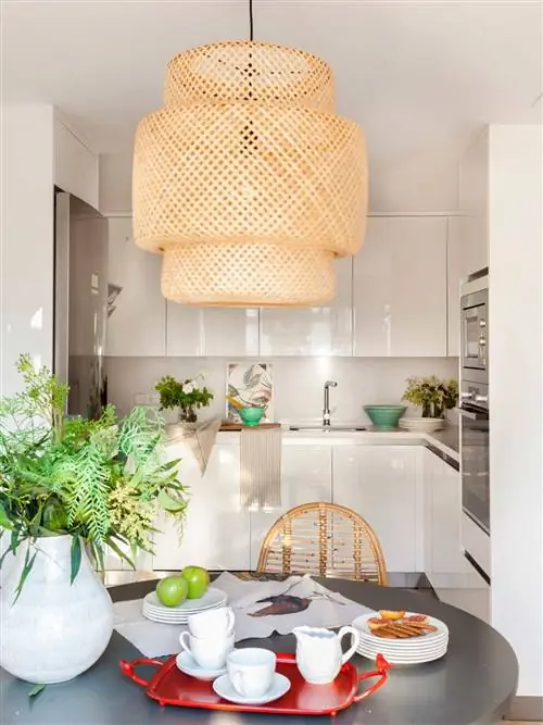 Небольшая кухня с белыми глянцевыми шкафами.