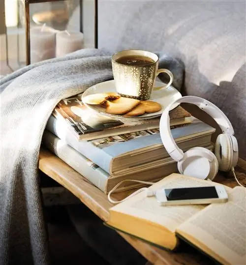мобильный с наушниками на книгах