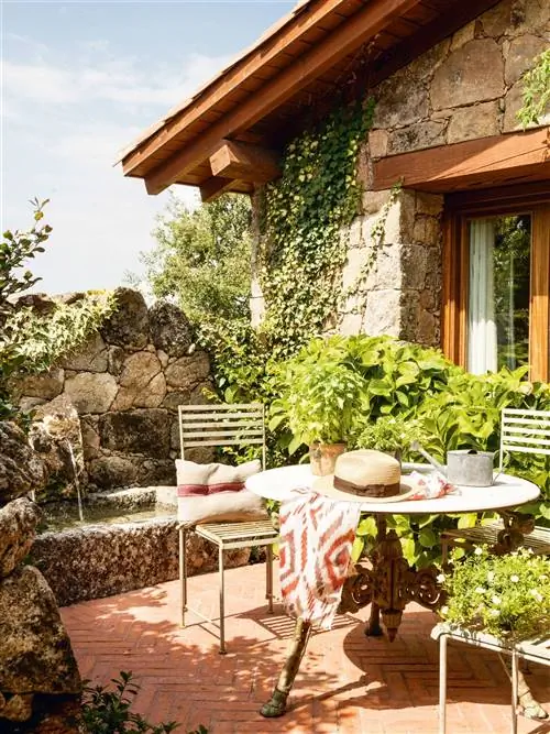 терраса со столом и стульями из кованого железа и каменным фонтаном 00412161