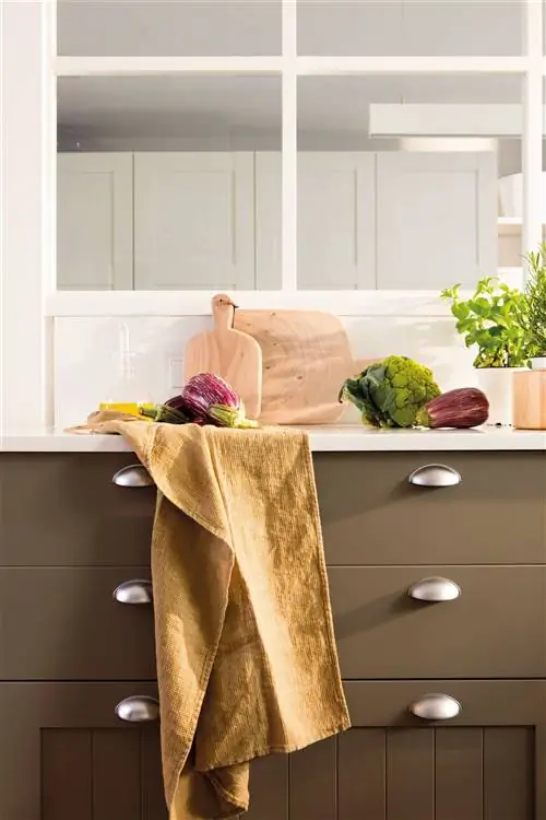 Кухонный прилавок с коричневыми ящиками, тряпкой и деревянными досками