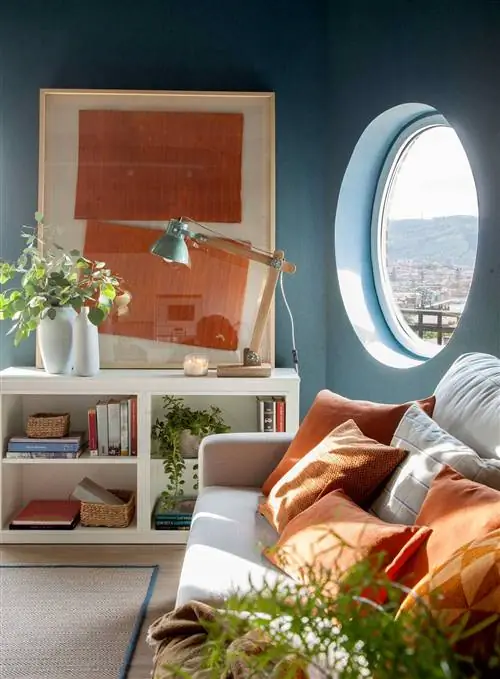 Гостиная с голубыми стенами и лампой на низком шкафчике_00511449 O