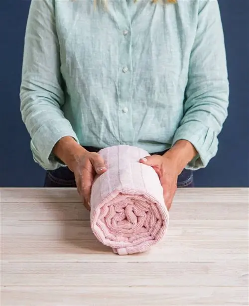 Женщина складывает полотенца по методу Мари Кондо 00498044_O