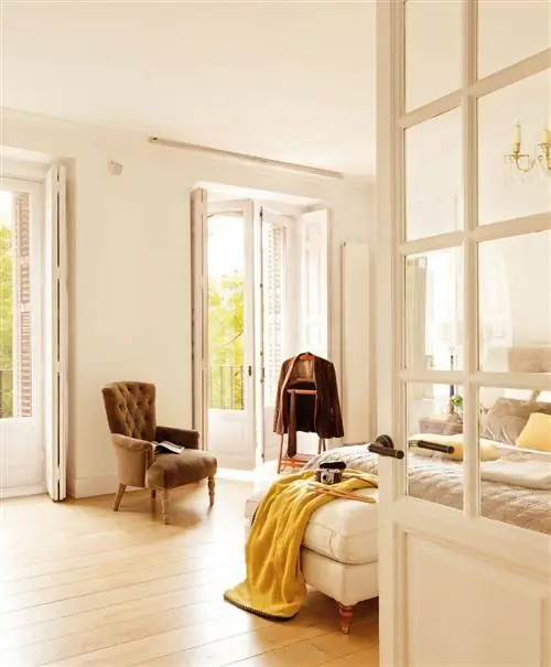 Спальня с бархатным креслом с капитоне, костюмом камердинера и пуфом у изножья кровати