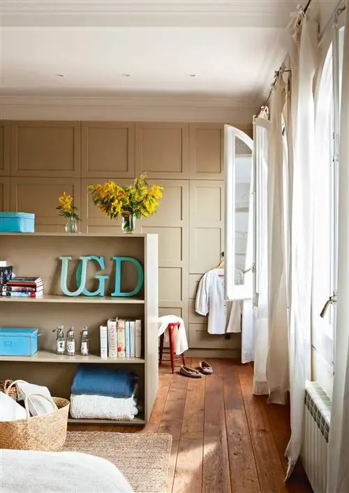 Гардеробная-в-спальне, разделенная-низкой-библиотекой-окрашенной-в-зелено-серый-00381001