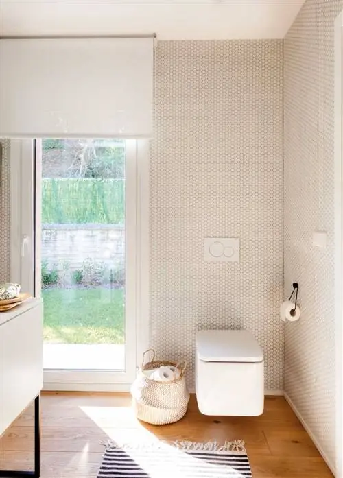 Современная ванная комната с подвесным унитазом и встроенным бачком.