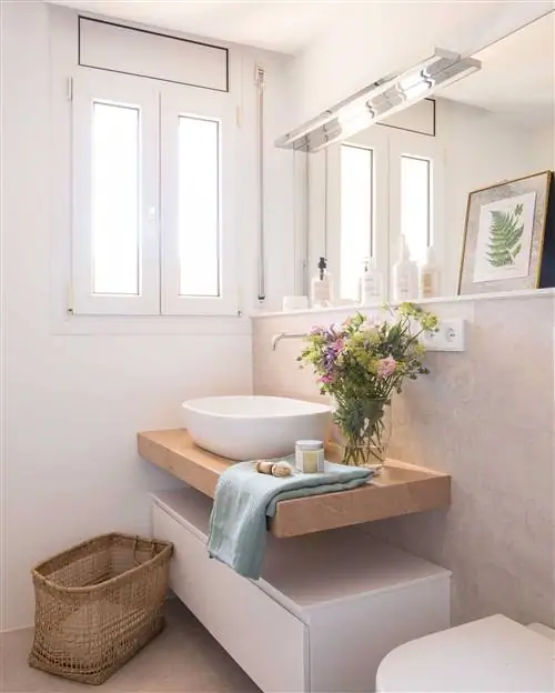 Современная ванная комната с белым шкафом для раковины и деревянной столешницей.