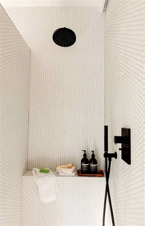 Душ с полкой и кранами черного цвета.