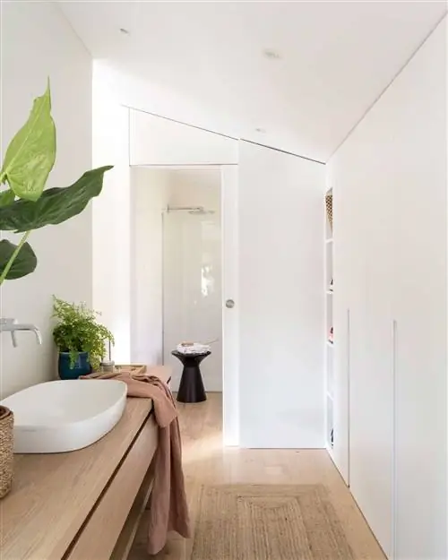 Современная белая ванная комната с гардеробной.