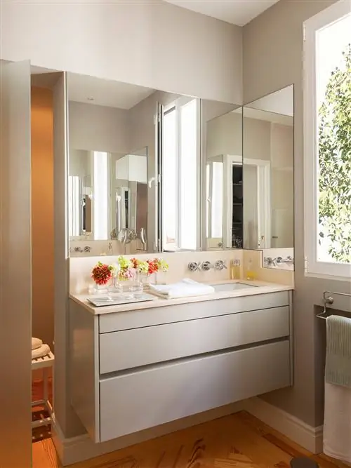 Современная ванная комната с серым шкафом раковины.