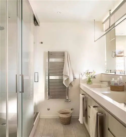 Санузел с мебелью на одну сторону, кабинки с душем и туалетом и полотенцесушителем.