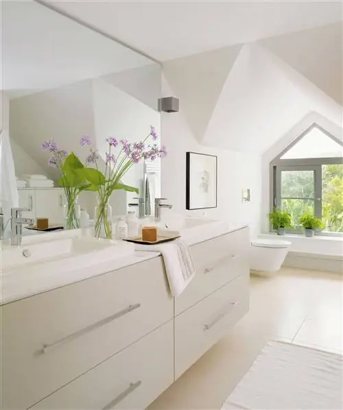 Современная ванная комната с белой подвесной мебелью.