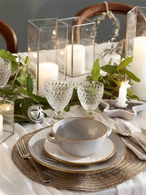 Стол накрыт к Рождеству тарелками.