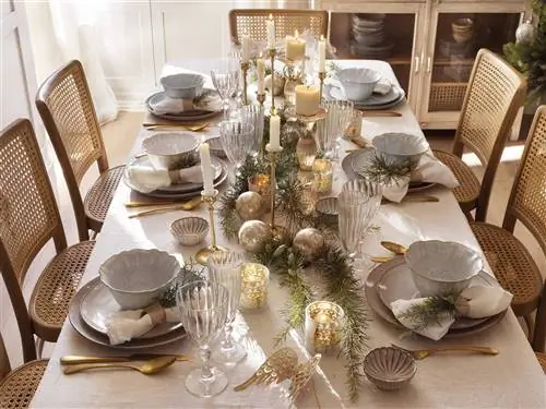 Рождественский стол с серой скатертью и золотыми украшениями.