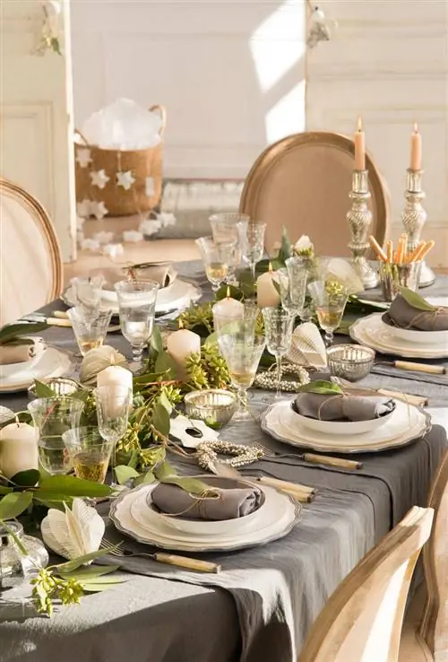 Рождественский стол с серой скатертью и белой посудой.
