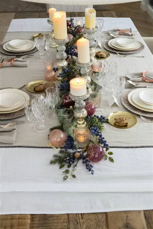 Рождественский стол с центром из гирлянд и шаров.