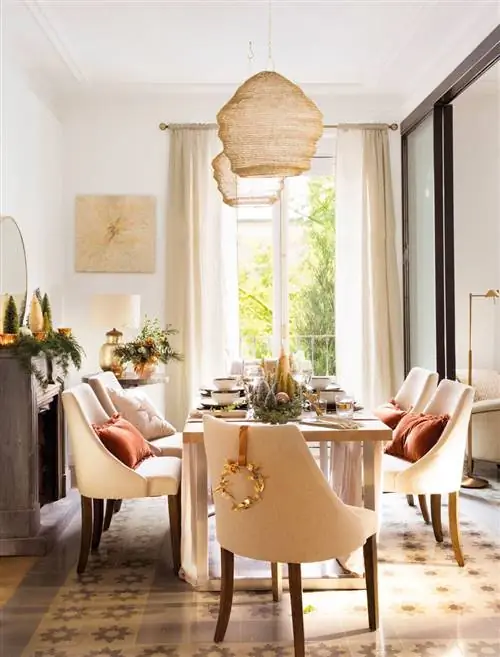 Рождественская столовая со стульями, украшенными венком.