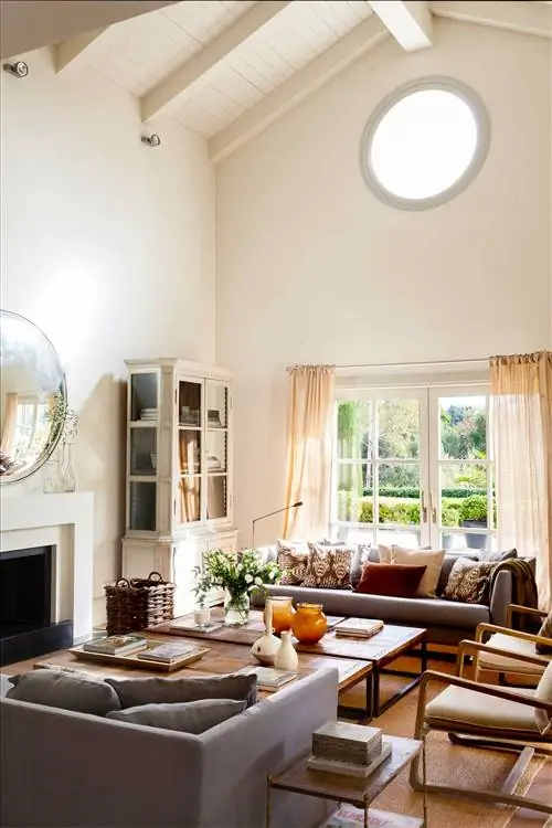 Гостиная с очень высокими потолками с двумя темными диванами, стоящими друг напротив друга 00531844