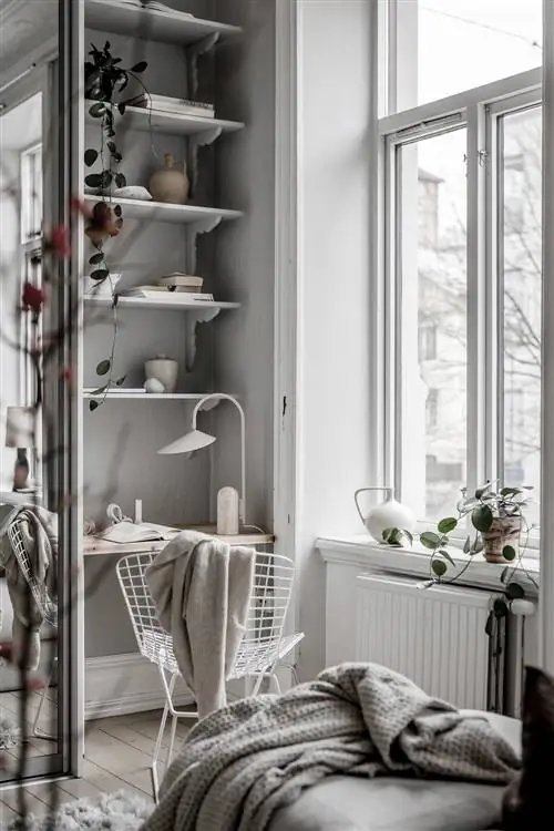 Стол в скандинавском стиле, оформленный в бело-серых тонах, с несколькими полками