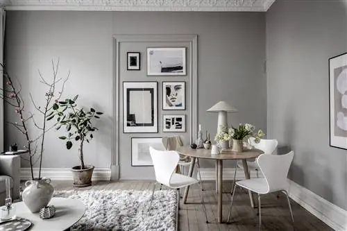 Столовая в скандинавском стиле оформлена в бело-серых тонах с лепниной на потолке.