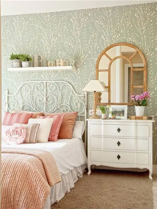 Спальня с белым изголовьем из кованого железа.