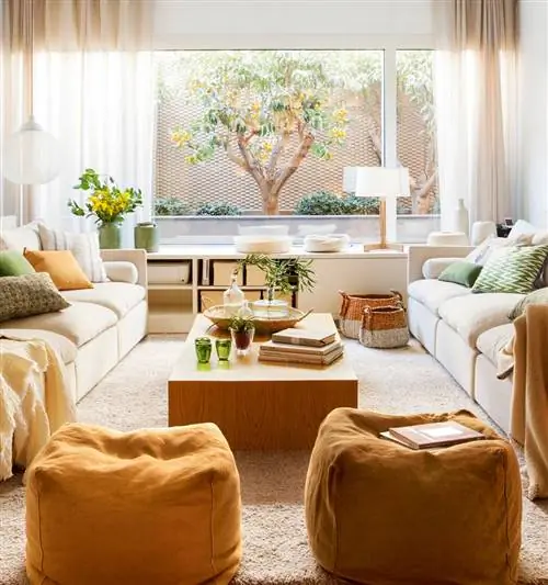 Гостиная с белыми диванами, горчичными пуфами и деревянным журнальным столиком