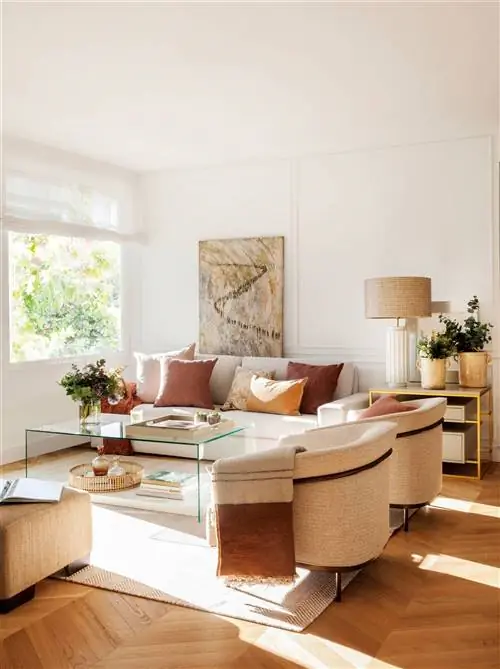 Гостиная дома дизайнера интерьеров Лусии Мариньяс с белым диваном, креслами и картиной Долорс Комас.