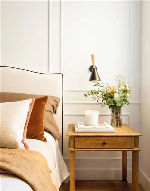 Стена изголовья украшена молдингами