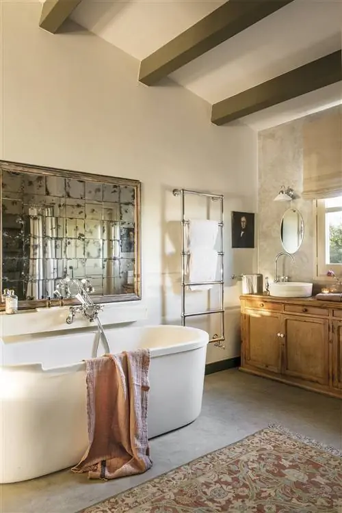 Ванная комната с ванной и состаренным зеркалом.