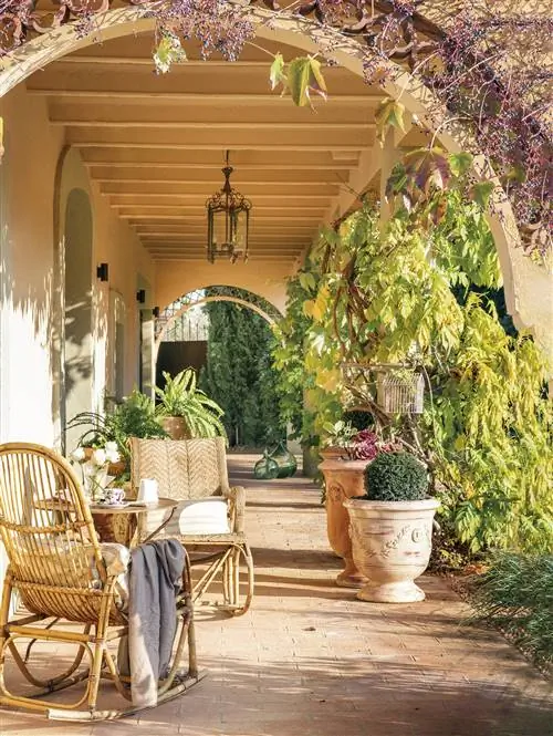 Крыльцо с деревянными балками и садовой мебелью.