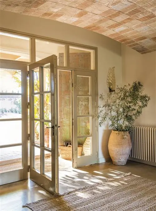 Вестибюль со сводчатыми потолками и застекленными деревянными дверями.