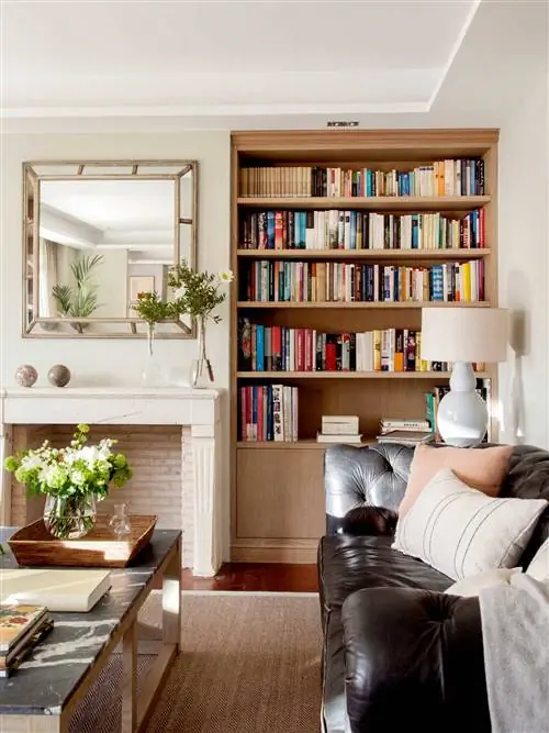 Деревянный книжный шкаф в гостиной с камином.