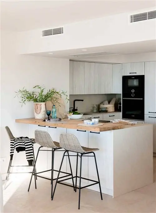 Небольшая открытая U-образная кухня с деревянной барной стойкой