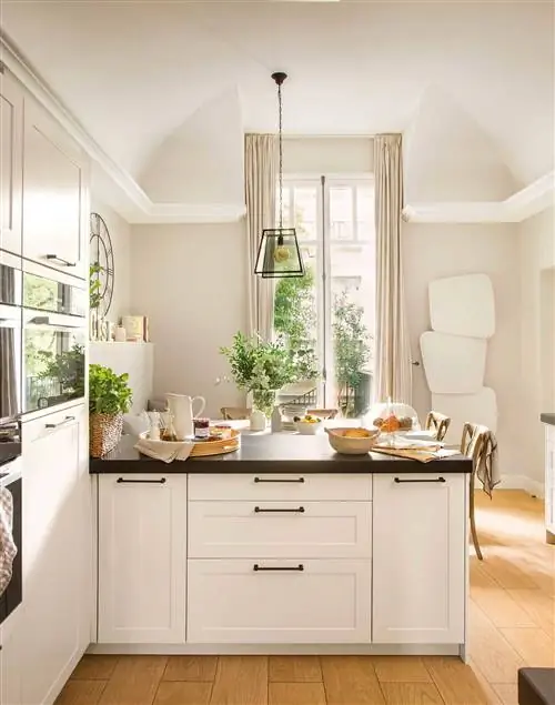 Белая кухня с черной столешницей и кабинетом.